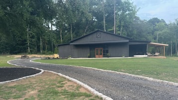 A building with a gravel driveway and a lawn.