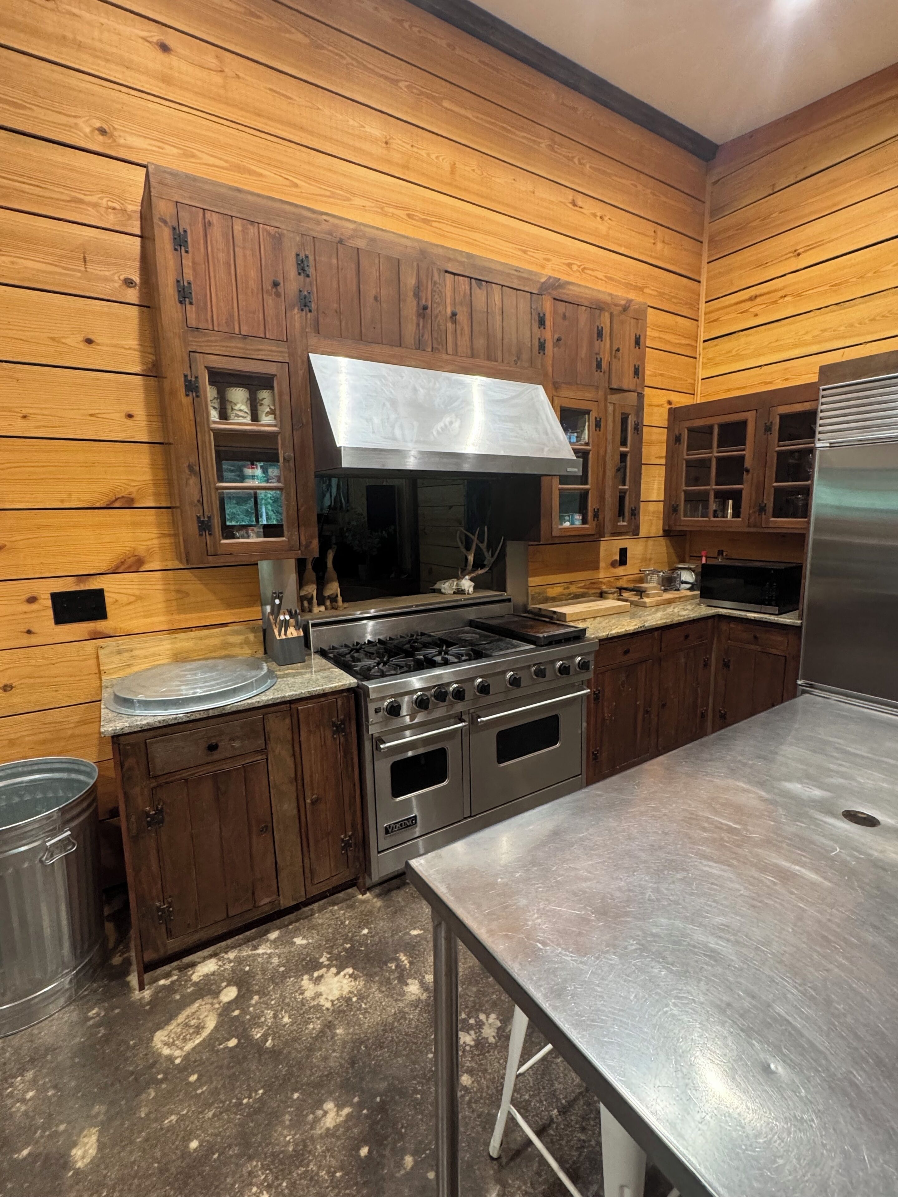 Une cuisine avec des meubles en bois, une cuisinière en acier inoxydable et un réfrigérateur.