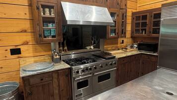 Une cuisine avec des meubles en bois, une cuisinière en acier inoxydable et un réfrigérateur.