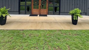 A building with a large wooden door, two potted plants, and a grassy area in front. - The Dugout! Family Retreat
Wiffle Ball, Pickleball, Basketball, Ping Pong & More (Hamilton)