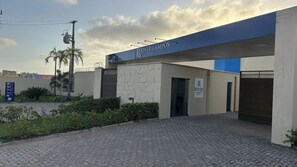 Exterior del Hotel River Campos con entrada pavimentada, un camino de acceso con puerta y cielo despejado.