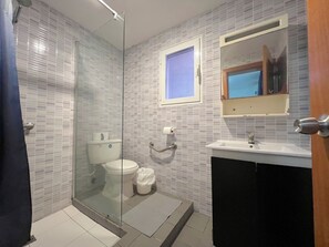 A bathroom with a glass shower enclosure, a toilet, a sink, and a mirror. - CARIBBEAN STUDIOS playa LOS CORALES (Punta Cana)