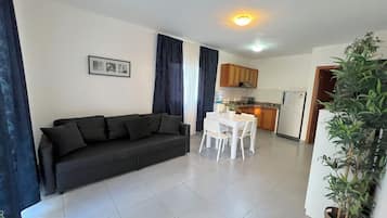 Suite Deluxe, balcón, vistas al jardín | Zona de estar | Una televisión LCD