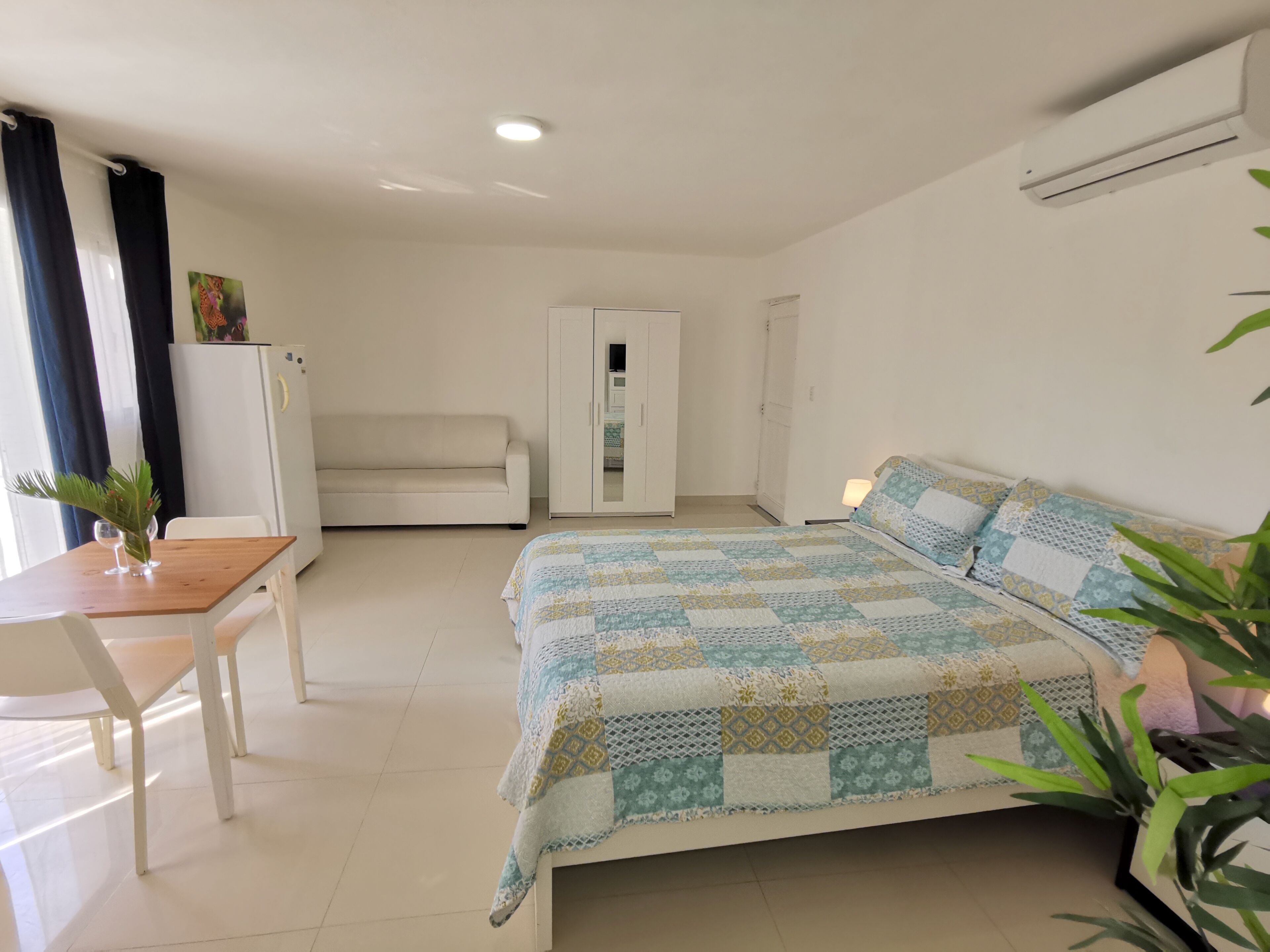 Un dormitorio con cama, sofá, escritorio y armario.