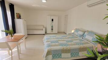 Un dormitorio con cama, sofá, escritorio y armario.