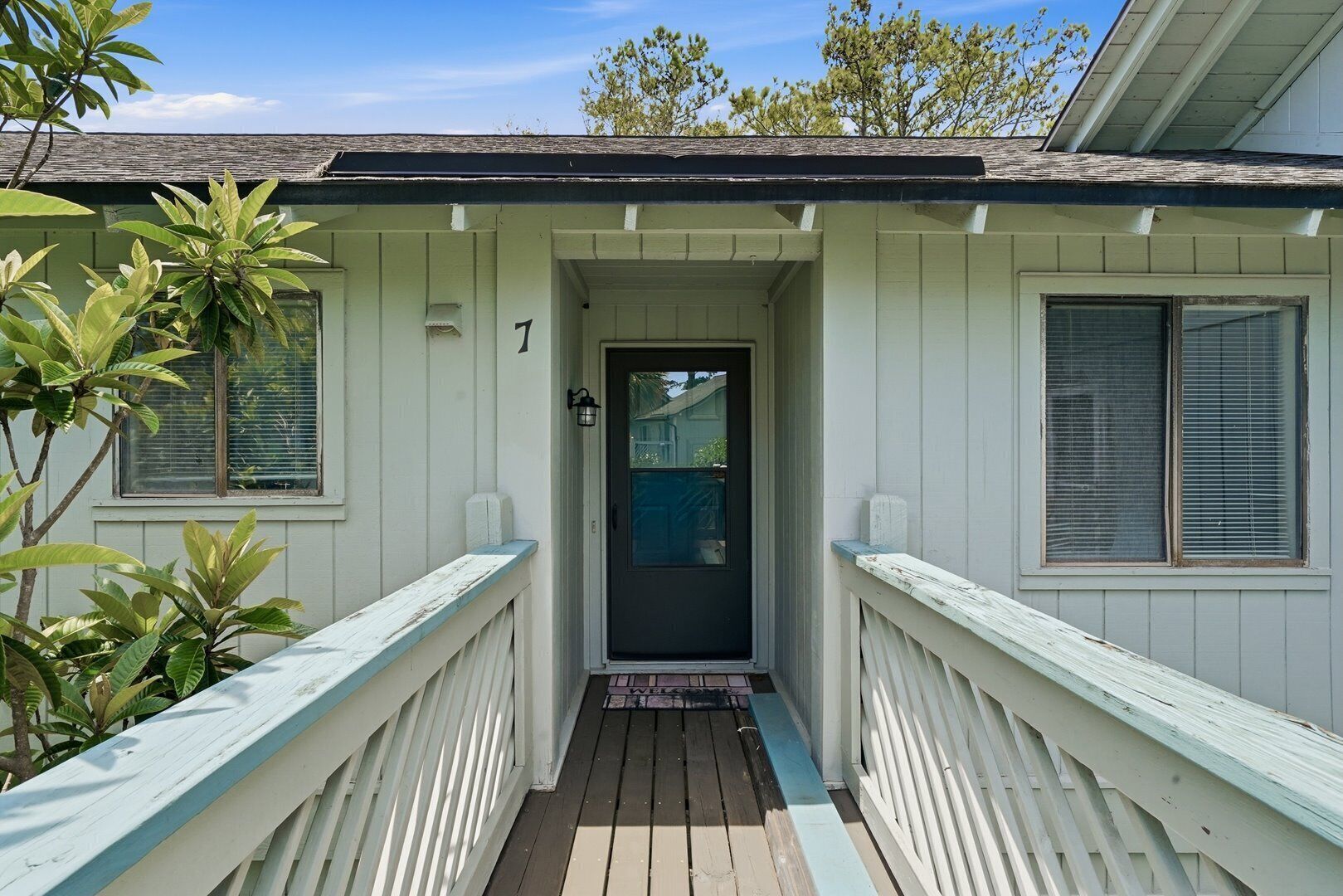 A house with a porch, a door, and a number '7' on the wall.
