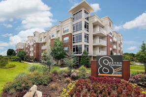 A multi-story apartment building with a sign indicating a metro station nearby. - Landing | Incredible 1BD, Gym, Clubhouse (Charlotte)