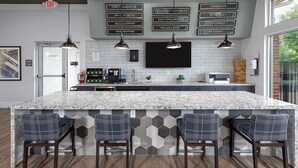 A modern kitchen with a large island, bar stools, a coffee machine, and a TV mounted on the wall. - Landing | Incredible 1BD, Gym, Yoga Studio (Charlotte)