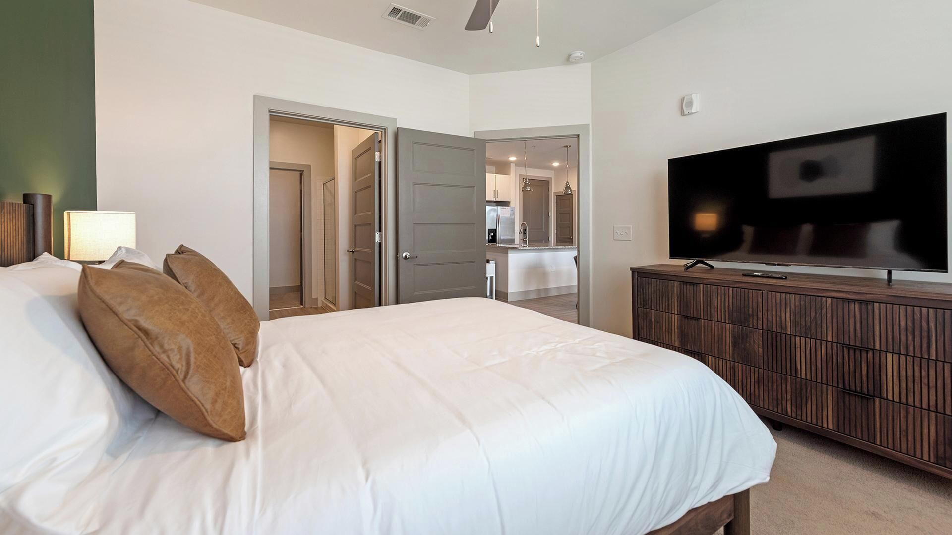 Une chambre d’hôtel comprenant un lit, une télévision, une armoire et une porte donnant accès à une salle de bain.