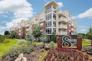 A multi-story apartment building with a sign indicating a metro station nearby. - Landing | Spectacular 1BD, Gym, Clubhouse (Charlotte)