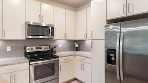A kitchen with stainless steel appliances, light wood cabinets, and a granite countertop. - Landing | Amazing 1BD, Gym, Clubhouse (Charlotte)