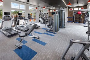 A gym with treadmills, weight machines, and a bench press area. - Landing | Amazing 1BD, Gym, Clubhouse (Charlotte)