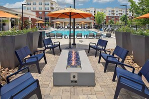 A poolside area with lounge chairs, a fire feature, and umbrellas. - Landing | Amazing 1BD, Gym, Clubhouse (Charlotte)