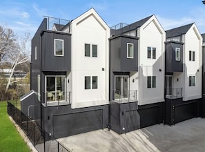 A modern multi-story residential building with a flat roof, large windows, and a gated driveway. - Landing | Stylish 3BD in Dallas (Dallas)