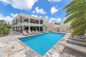 A two-story building with a swimming pool, outdoor seating, and a staircase leading to an upper level. - Villa Mira Alma full house Contemporary Luxury Villa in the Heart of Jan Thiel (Jan Thiel)