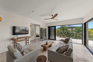 A modern living room with a flat-screen TV, two sofas, a coffee table, and a ceiling fan. - Villa Mira Alma full house Contemporary Luxury Villa in the Heart of Jan Thiel (Jan Thiel)