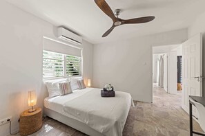 A bedroom with a bed, a ceiling fan, an air conditioning unit, a bedside lamp, and a window with blinds. - Villa Mira Alma full house Contemporary Luxury Villa in the Heart of Jan Thiel (Jan Thiel)