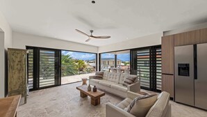 Ein geräumiger Wohnbereich mit Sofa, Couchtisch und Deckenventilator.