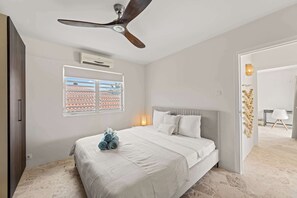 A bedroom with a bed, a ceiling fan, an air conditioning unit, a window with blinds, and a view of the outside. - Villa Mira Alma full house Contemporary Luxury Villa in the Heart of Jan Thiel (Jan Thiel)