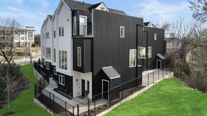 A modern two-story residential building with a flat roof, large windows, and a black and white exterior. - Landing | Amazing 3BD in Dallas (Dallas)