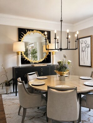 A dining room with a large oval mirror, a chandelier, and a framed botanical print on the wall. - Private Luxury Estate-Large Fishing Pond-Pool-Event/Wedding Venue (Benton)