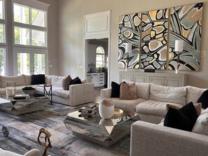 A modern living room with a sectional sofa, a coffee table, and abstract art on the wall. - Private Luxury Estate-Large Fishing Pond-Pool-Event/Wedding Venue (Benton)
