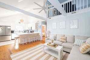 A spacious living area with a white sofa, a coffee table, and a striped rug. - Newly Renovated Family Home in Ocean Sands (Corolla)