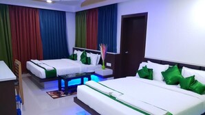 Une chambre d’hôtel avec deux lits, un bureau et une petite table.