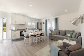 A modern apartment with a kitchen, dining area, and living room. - Casa Amável - Vila Serena (Caldas da Rainha)