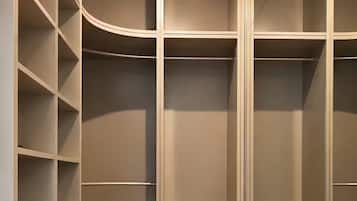 Ein begehbarer Kleiderschrank mit offenen Regalen, Schubladen und einer spiegelnden Schiebetür.
