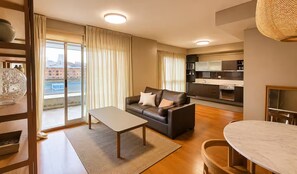 Ein modernes Wohnzimmer mit Sofa, Couchtisch und Esstisch.