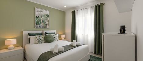 Une chambre d’hôtel moderne avec un grand lit, une table de chevet avec une lampe, un tableau au mur et une machine à café.