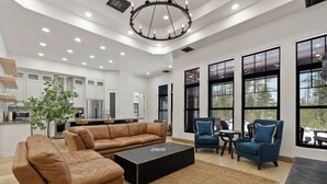 Una sala moderna con un sofá de cuero, una mesa de centro y dos sillones.