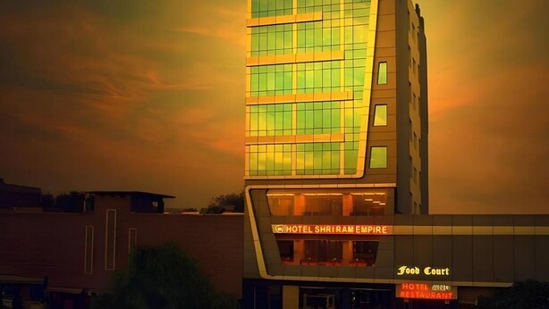 A hotel with a modern design, featuring a prominent glass facade and signage for the 'Hotel Shriram Empire' and 'Food Court.' - Shri Ram Empire (Jodhpur)