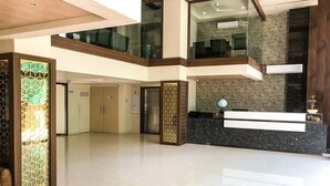 Vestíbulo de hotel con mostrador de recepción, una escalera y una pared decorativa.
