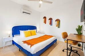Ein Schlafzimmer mit Bett, Nachttisch, Stuhl, Schreibtisch und Wanddekorationen.