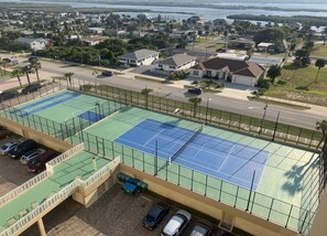 A tennis court with a parking area and a view of a residential neighborhood. - #207 3BR 3.5BA  Direct Ocean, Full Remodel, 2K + 2Q, Indoor Laundry, Gorgeous (Daytona Beach Shores)