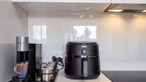 Ett modernt kök med en kaffemaskin, en vattenautomat och en vattenkokare.