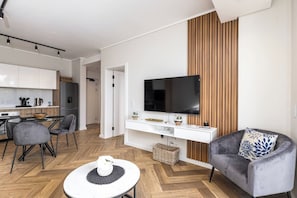 A modern living space with a dining area, a kitchen, and a seating area with a flat-screen TV. - Modern Luxury at Park Place by Ctha (Cape Town)