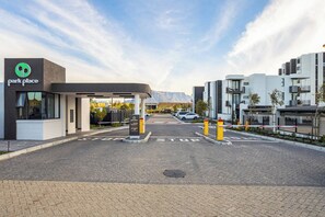 A parking area with a 'park place' sign, a gated entrance, and a modern building in the background. - Modern Luxury at Park Place by Ctha (Cape Town)