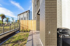 A residential building with a brick exterior, a wooden fence, and a barbecue grill. - Modern Luxury at Park Place by Ctha (Cape Town)