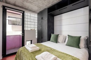 Ein Hotelzimmer mit Bett, Kleiderschrank und einem Fenster mit Blick.