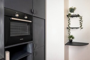 Eine moderne Küche mit Backofen von Bosch, schwarzen Schränken und minimalistischem Design.