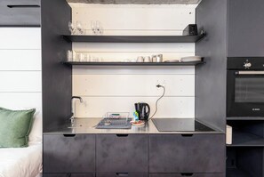 Eine Küchenzeile mit Backofen von Bosch, einer Kaffeemaschine und einem Wasserkocher auf der Arbeitsfläche.