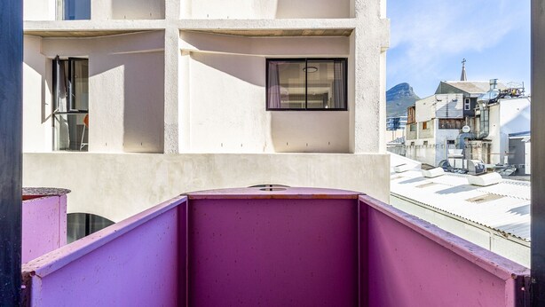 A multi-story building with balconies, a clear sky, and a distant mountain. - The Urban Nest by CTHA (Cape Town)