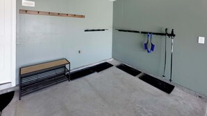 A room with a bench, a wall-mounted rack, and a tool rack with shovels. - Ski Haven Hideaway 15 Mins to Park City Slopes (Hideout)