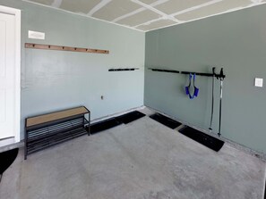 A room with a bench, a wall-mounted rack, and a tool rack with shovels. - Ski Haven Hideaway 15 Mins to Park City Slopes (Hideout)
