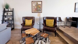 A living room with two leather armchairs, a wooden coffee table, a fur rug, a grey sofa, a bookshelf, and a framed artwork on the wall. - Ski Haven Hideaway 15 Mins to Park City Slopes (Hideout)
