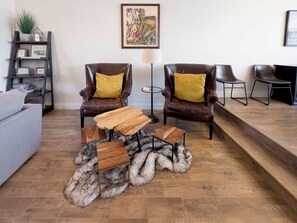 A living room with two leather armchairs, a wooden coffee table, a fur rug, a grey sofa, a bookshelf, and a framed artwork on the wall. - Ski Haven Hideaway 15 Mins to Park City Slopes (Hideout)