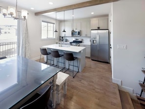 A modern kitchen with a central island, bar stools, stainless steel appliances, and pendant lighting. - Ski Haven Hideaway 15 Mins to Park City Slopes (Hideout)